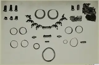 Gold and silver rings, bracelets and a bead necklace from Ayios Iakovos, laid out in rows on a pale background