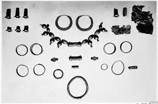 Rings, bracelets, beads and a necklace from the Ayios Iakovos Bronze Age sanctuary, laid out in rows on a pale background
