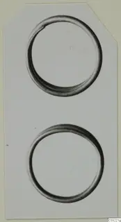 Two plain metal rings, one above the other, photographed on a pale card.
