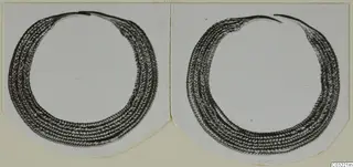 Two ring-shaped objects with herringbone-patterned bands, shown side by side on a pale card mount