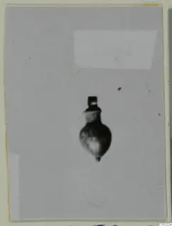 Small pendant with a loop at the top and a rounded, bulbous body, photographed on a grey ground.