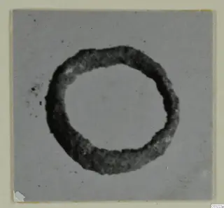 Ring-shaped silver object from Marion, photographed on a grey card