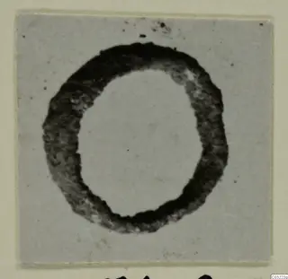 Dark ring-shaped object from Marion Tomb 60, photographed on a grey card mount