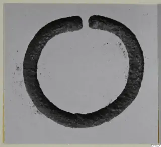 Open silver ring with a gap at the top, tarnished dark, shown against a pale plain background