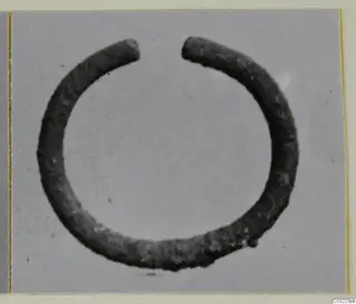 Open silver ring with two plain ends, photographed against a grey backdrop.