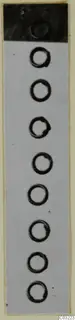 Vertical row of about eight bronze rings on a pale ground, with a dark band across the top