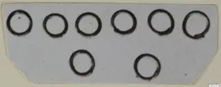 Eight dark ink rings drawn on a pale card, arranged in two rows of six and two.