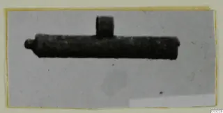 Find photograph of a silver object: a dark tube with a short upright projection and a small knob at one end