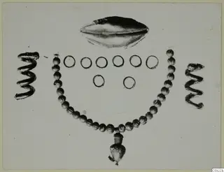 Jewellery from Marion: a curved bead necklace, two spiral wire pieces, a group of plain rings and an oval object.