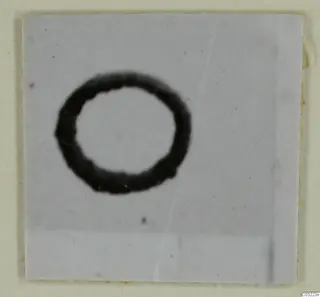 Blurred dark ring-shaped object on a pale square ground, labelled as a silver find from Marion, M. 44