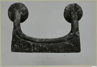 Bronze mounting from Marion: a U-shaped bar with a round knob at each end, on a rectangular base plate