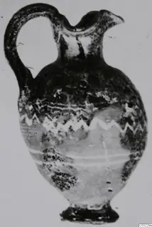 Sand-core glass jug with a loop handle and light zigzag trails