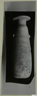 Pale stone vessel with a wide flat rim, narrow neck and two small handles, shown against a black backdrop