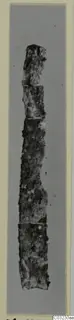 Corroded iron tool from Marion Tomb 56, shown broken into several pieces against a grey backdrop.