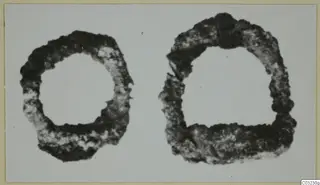 Two corroded iron objects, one circular and one semicircular, shown side by side.