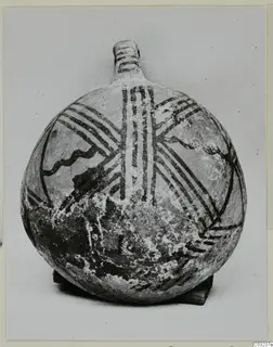 Round-bodied painted pottery vessel with a short neck, decorated with dark bands, standing on a small wooden block.