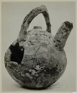 Pottery jug with a strap handle and a side spout, broken open on one side, from the Vrysi tou Barba tombs at Lapithos.