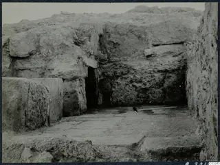 Excavated area at the palace at Vouni, with large stone blocks, a dark doorway and a paved stone floor