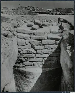 Excavated stone wall of rough blocks in a deep trench at the palace at Vouni