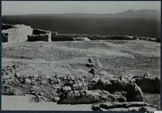 Ruined walls and scattered stones at Vouni palace, with the sea and a distant mountain range behind