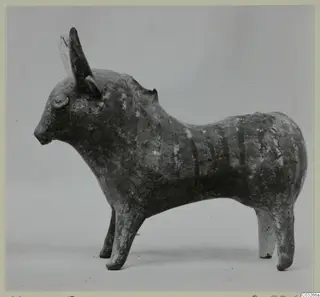 Clay figurine of a standing bull with horns and dark body stripes, from Milia