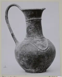 Pottery jug with a single loop handle, flared mouth and raised band on the body, from Milia