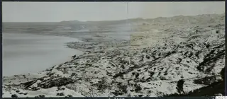 Panoramic view over the coast at Vouni, with calm sea on the left and dry, eroded hills rising inland
