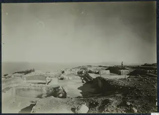 Excavated ruins of the palace at Vouni with cut stone walls and the sea beyond