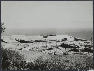 Ruined walls and scattered stones of the palace at Vouni on a hilltop, with the sea behind