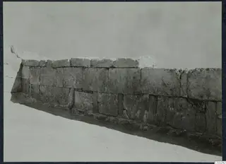 Long wall of large squared stone blocks running diagonally across a pale ground at Vouni palace.