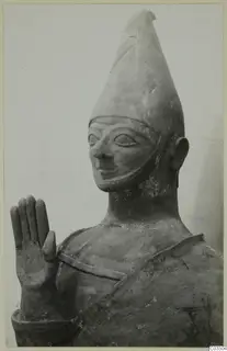 Terracotta Proto-Cypriote II: head and upper body of a terracotta statue with a tall conical headdress and raised hand
