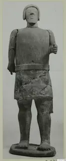 Terracotta Proto-Cypriote I, standing figure with a close-fitting head covering, a waist band over a short skirt, and one hand raised
