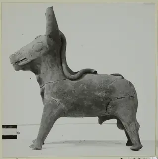 Terracotta figurine of a standing bull with a tall tubular spout on its head and a looped handle on its back