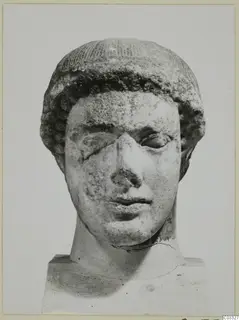 Marble head of a figure with curled hair, nose broken and one eye damaged, on a square base