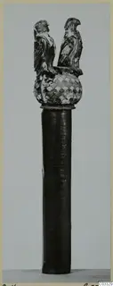 Dark cylindrical shaft topped by a scale-patterned knob and two bird figures