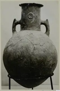 Red Polished III amphora from the Vrysi tou Barba tombs at Lapithos, two handles and a flared neck, on a metal stand