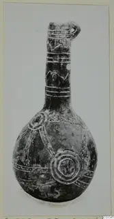Dark polished pottery vessel with a long neck and round body, decorated with light bands and concentric circles