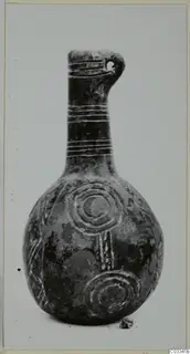 Black polished vessel with a long neck, incised grooves and concentric circles on the body