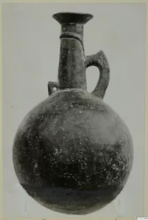 Pottery Red Polished III jug with a rounded body, tall flared neck and strap handle
