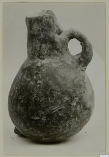Pottery Red Polished III jug with a rounded body, narrow neck and loop handle, photographed on a pale background