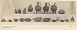 Pottery jugs, juglets and bowls from Lapithos Tomb 322 B, set out in two rows on a draped cloth