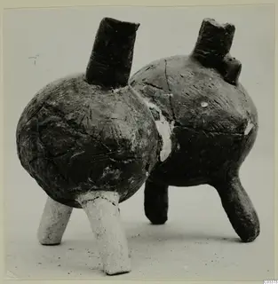 Two pottery vessels with tall necks and three short legs each, from the Vrysi tou Barba tombs at Lapithos