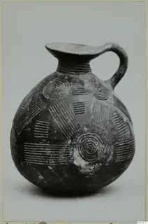 Pottery Red Polished II jug with a strap handle and incised concentric circles and parallel lines