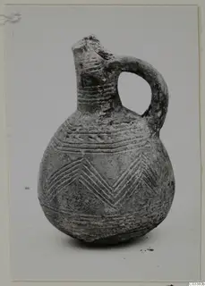 Pottery Red Polished III jug with a loop handle and incised band and chevron decoration
