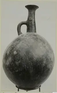 Pottery Red Polished II jug from Lapithos with a globular body, tall flared neck and single loop handle