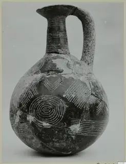 Red Polished II jug with a tall neck, strap handle and bands of lines and concentric circles decorating its body