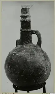 Red Polished III jug from the Vrysi tou Barba tombs at Lapithos, with a single loop handle and dotted neck bands