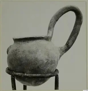 Pottery vessel with a single loop handle on a metal stand, find from the Vrysi tou Barba tombs at Lapithos