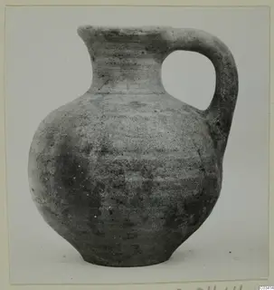 Plain wheel-made jug with a single loop handle and a narrow neck, shown against a light background.