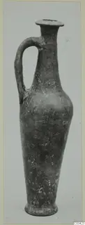 Pottery jug in Red Lustrous Ware with a single handle and flared rim, photographed against a pale background.